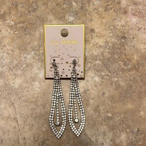 Silver long sparkly earrings. Never worn with price tag.